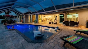 A covered outdoor swimming pool with lounge chairs and a patio area. - Boaters Dream, open water, heated pool, sleeps 6 (Gulf cove)