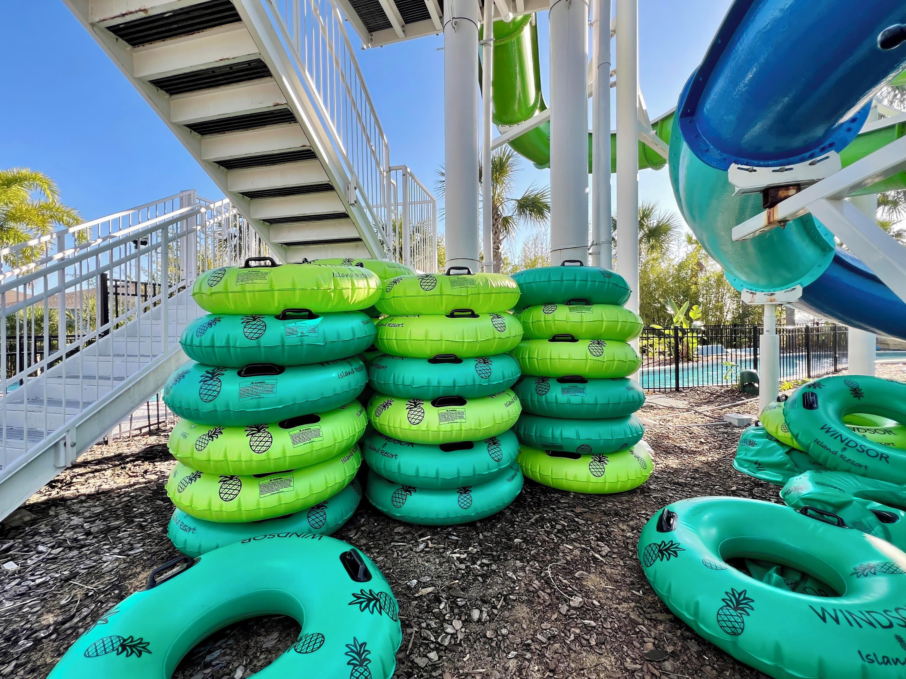A water slide with inflatable rings stacked on the ground.