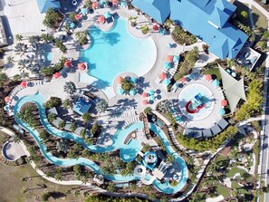 A resort with a large central pool, multiple smaller pools, and a water slide.