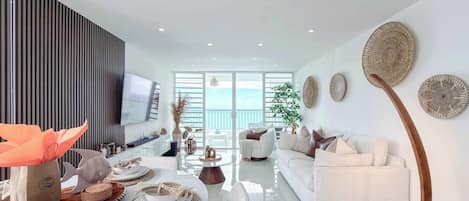 A modern living room with a sofa, TV, and decorative wall art.