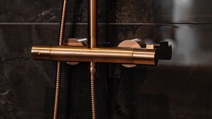Un baño moderno con un grifo metálico elegante y un cabezal de ducha de mano.
