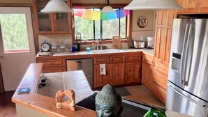 A modern kitchen with wooden cabinets, stainless steel appliances, and a central island.