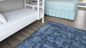 A bunk bed room with a blue patterned rug, a light blue bedspread, and a view of the ocean through a door. - 11A - 1BR $700+ in freebies incl golf, On Beach (Miramar Beach)