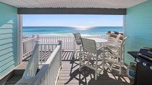 A covered outdoor seating area with a view of the ocean. - Miramar Beach 2BR • Beach + Free Beach Setup & Fun (Miramar Beach)
