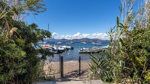 A marina with boats docked, surrounded by greenery and a clear sky.
