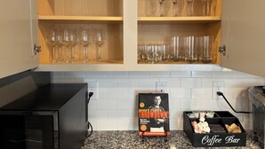 A kitchen with a coffee bar, a cookbook, and wine glasses on shelves. - Chic Family Home Near All ATL Hotspots (Atlanta)