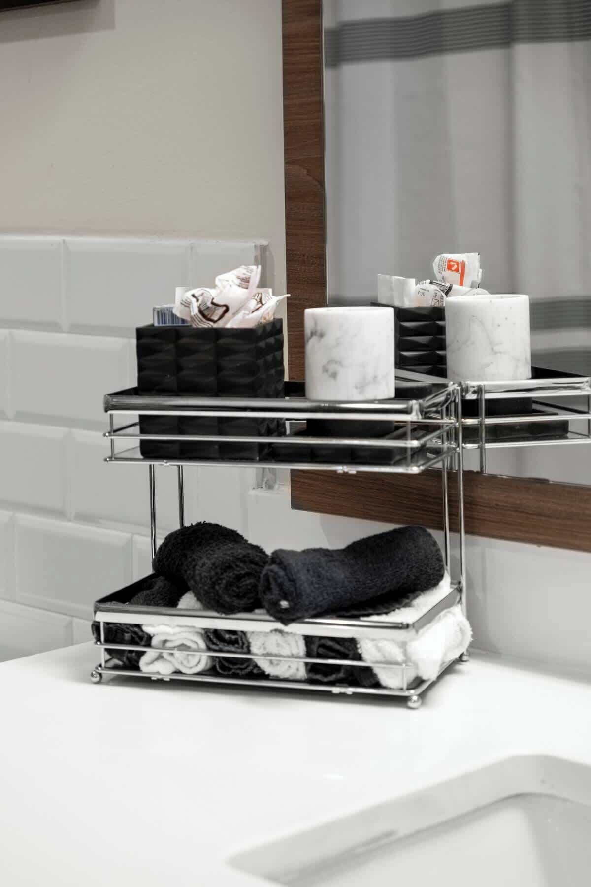 A bathroom with a three-tiered metal rack holding towels and toiletries.