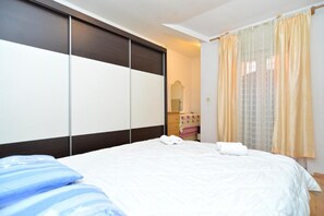 A hotel room with a bed, a wardrobe, a mirror, and a window with curtains. - Idyllic Escape in Fasana, Relax and Unwind (Fazana)