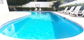 Relax by the pool with comfortable lounge chairs and a shaded area.