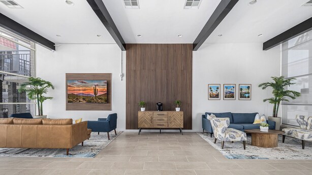 Un salon moderne comprenant un canapé, des fauteuils, une table basse et un meuble décoratif.
