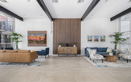 A modern living room with a sofa, armchairs, a coffee table, and a decorative cabinet.