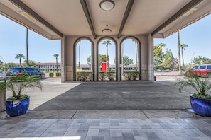 A covered parking area with a clear view of the street and buildings in the background. - Tempe Oasis (Tempe)