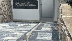 Ein Gebäudeeingang mit einem Schild, auf dem „Next Room“ steht, und einer Tür.