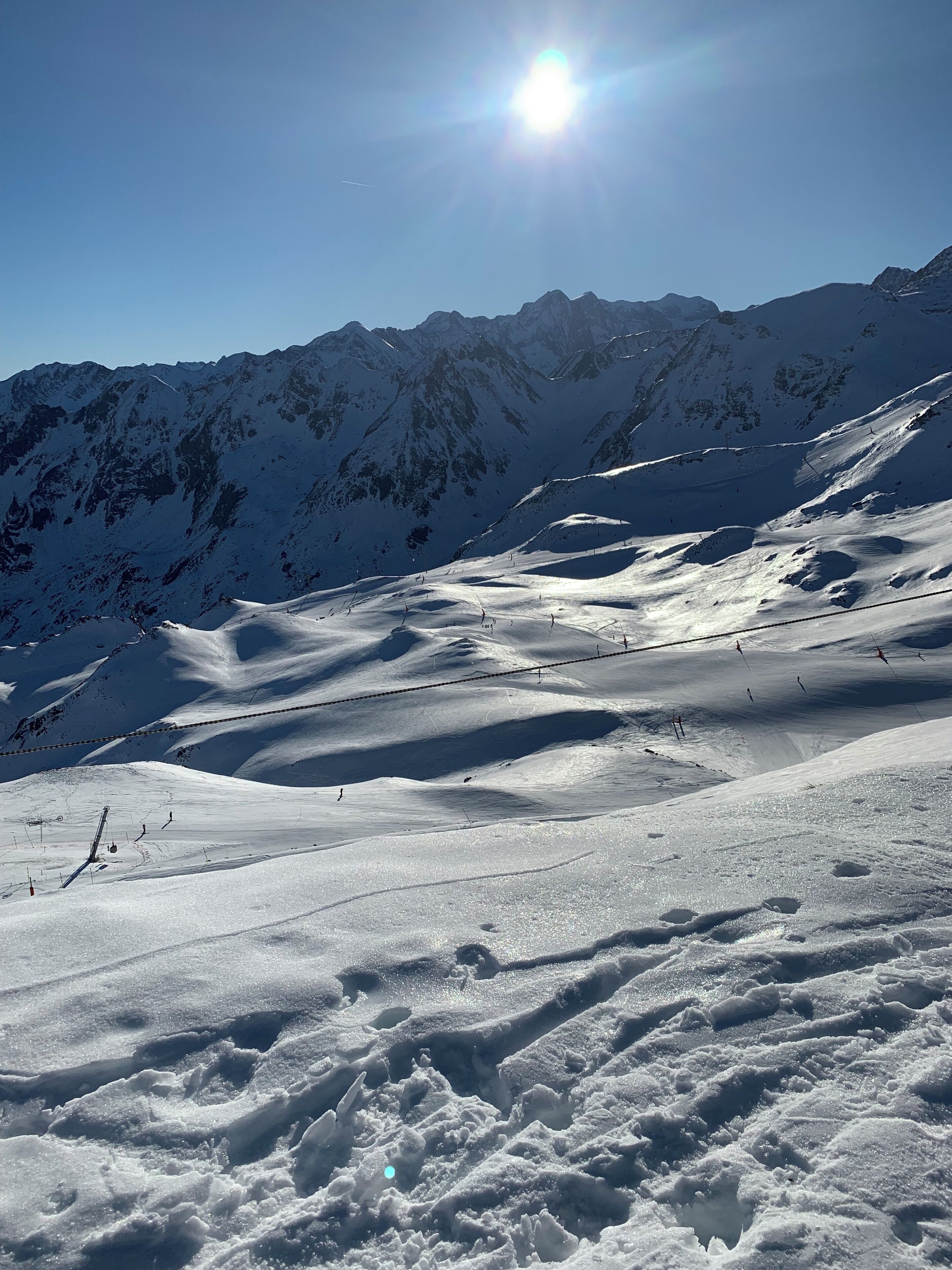 A snow-covered mountain landscape with ski slopes and a clear sky.