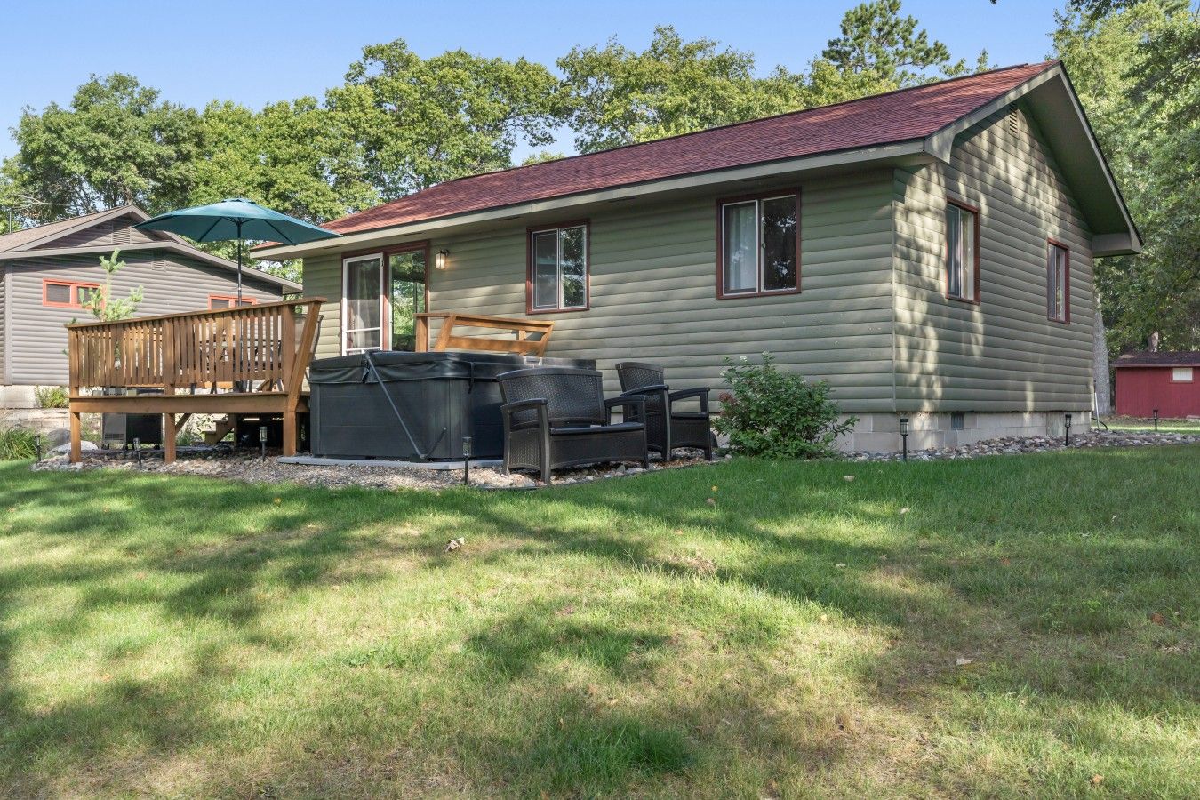 Un chalet de plain-pied doté d’une terrasse clôturée, de meubles de jardin et d’un bain à remous.