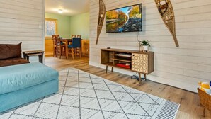 Un salon moderne avec un canapé, un téléviseur et des éléments de décoration murale en bois.