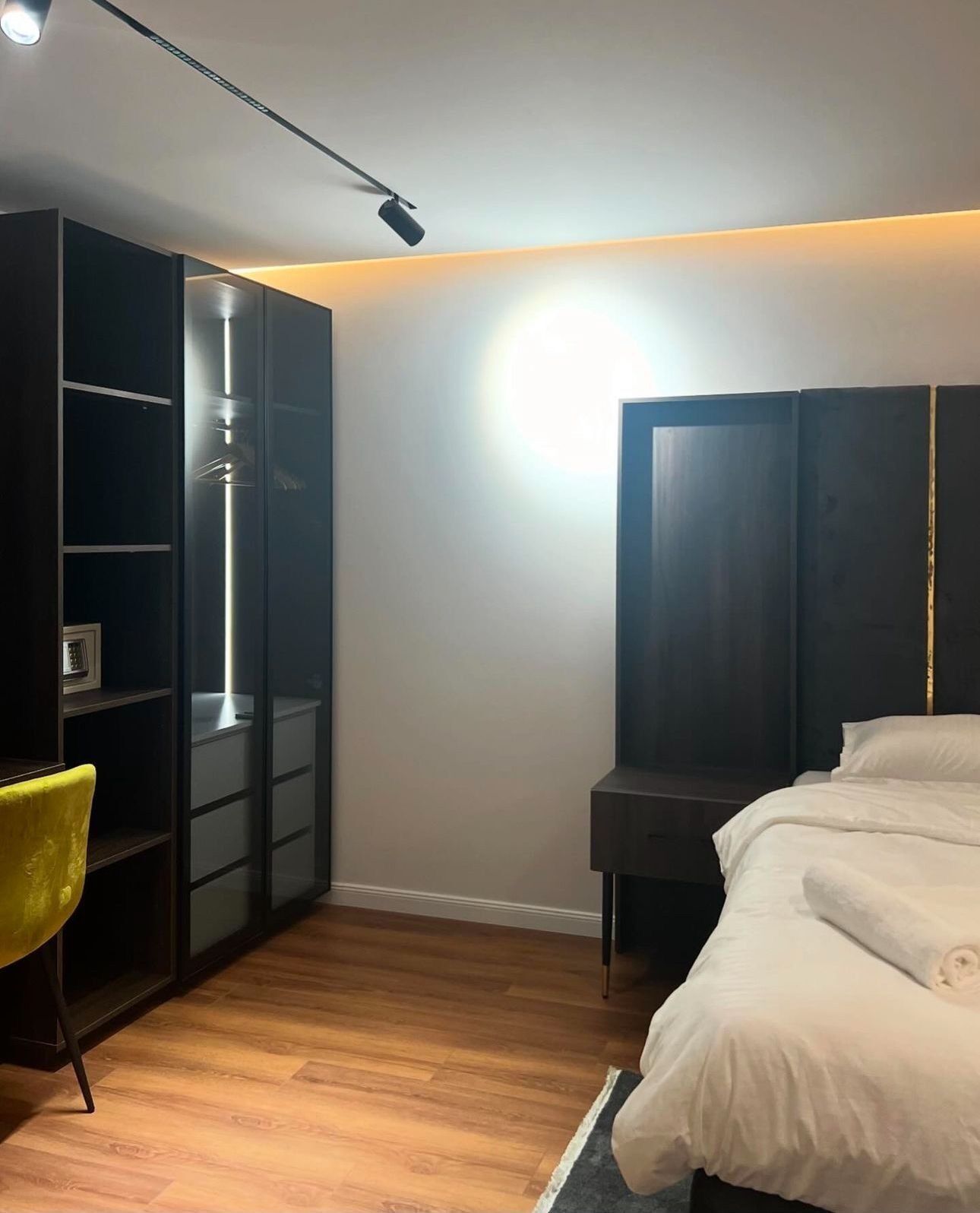 Un dormitorio con cama, armario y escritorio.