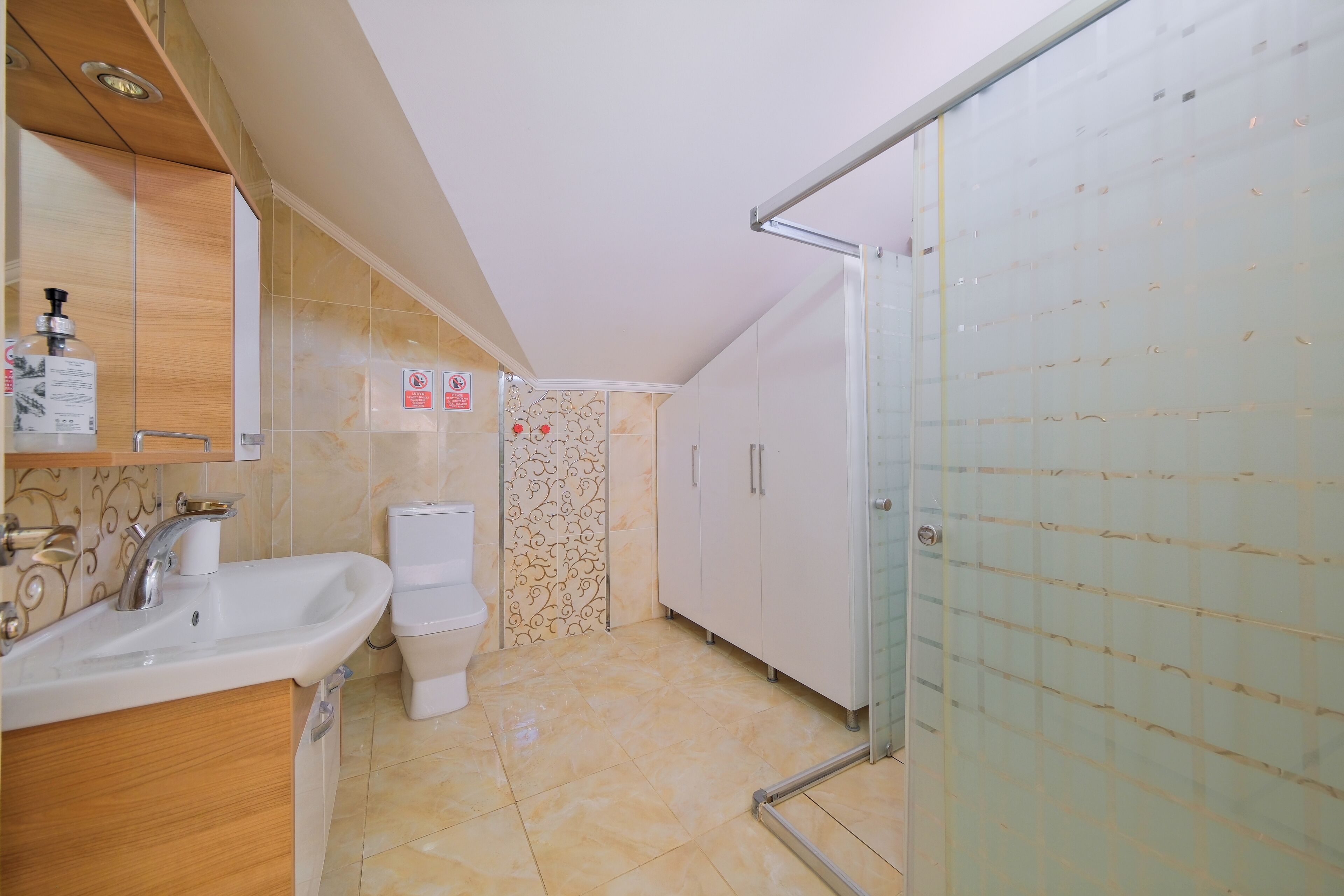 A modern bathroom with a sink, toilet, and shower area.