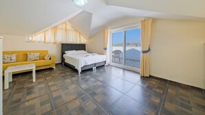A bedroom with a bed, a sofa, and a large window. - Villa Maya (Fethiye)