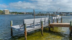 A wooden dock extending into a body of water with a marina in the background. - Unit #5 Waterfront + Heated Pool and Spa Access (Fort Walton Beach)