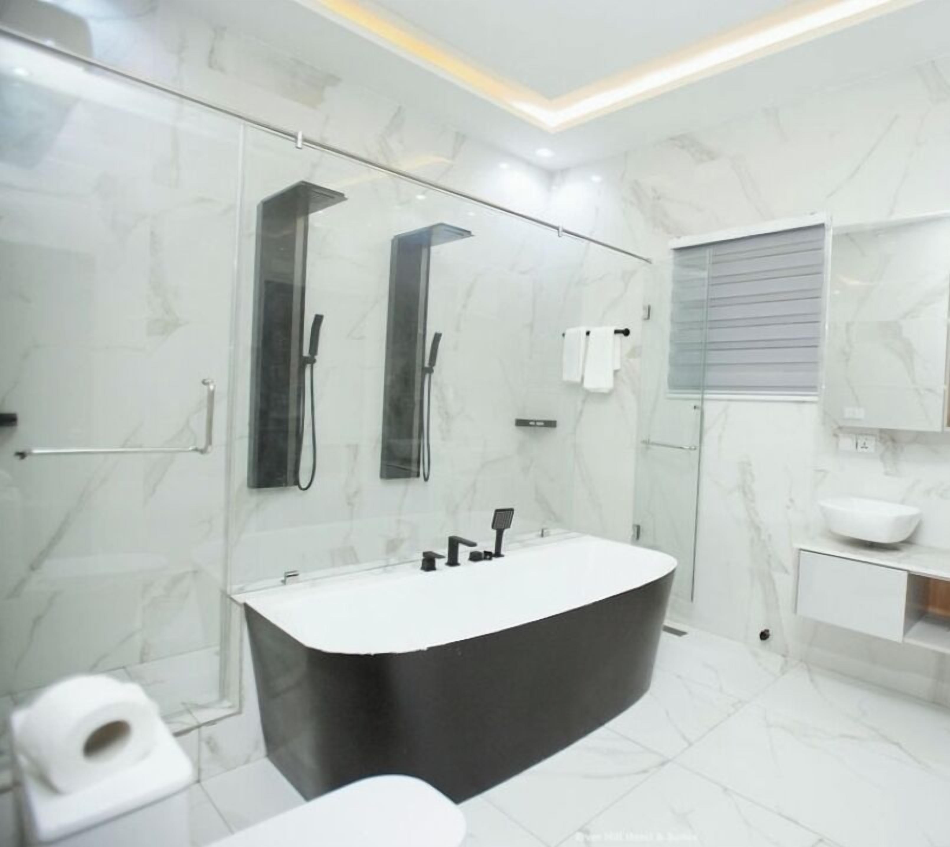 A modern bathroom with a large bathtub, a separate shower area, and a vanity with a sink and mirror.