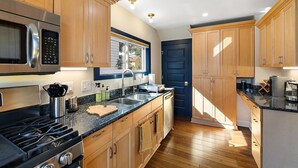 Una cocina moderna con armarios de madera, electrodomésticos de acero inoxidable y encimera de granito.