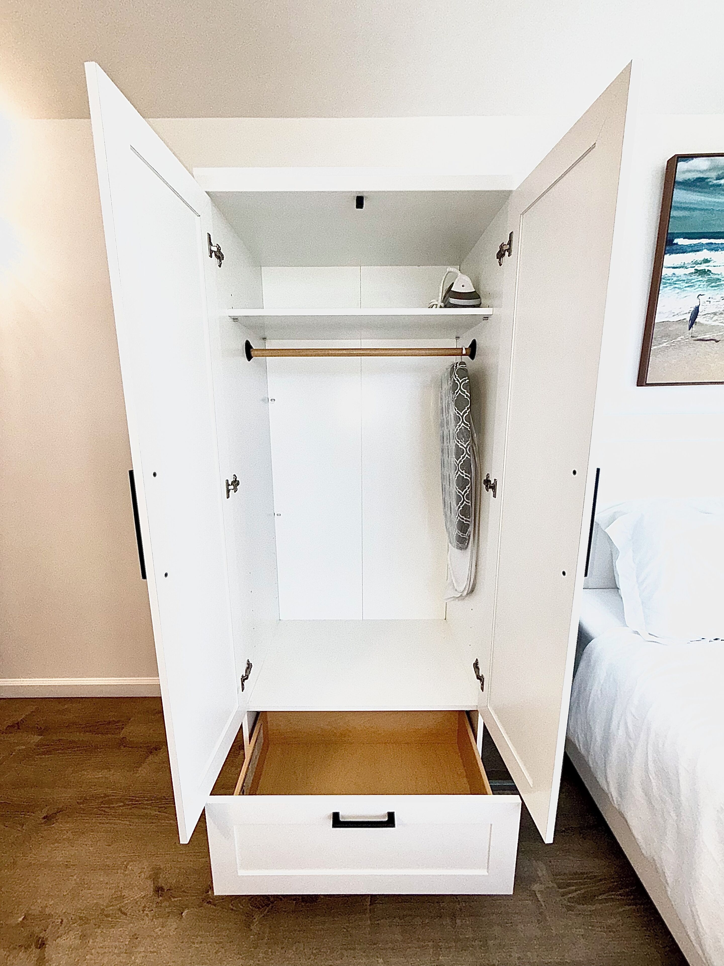 A walk-in closet with a hanging rod, a shoe rack, and a drawer.