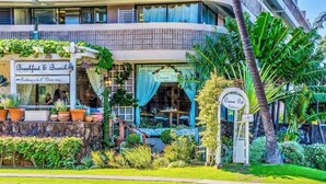 A restaurant with outdoor seating, a sign for 'Cream Pot', and a 'Breakfast & Brunch' sign. - Beautiful OCEAN & CANAL View - Renovated - Waikiki Studio (Honolulu)