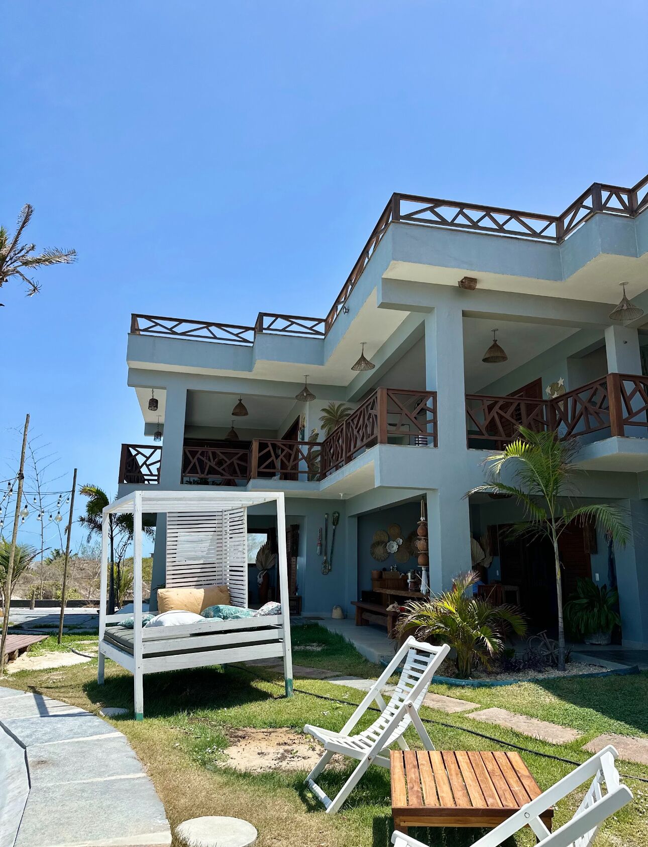 A two-story building with a balcony, outdoor seating area, and a covered seating area.