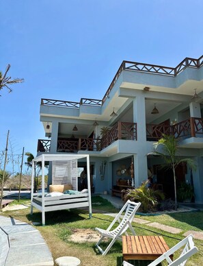 A two-story building with a balcony, outdoor seating area, and a covered seating area.