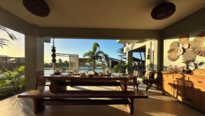 Comedor con vista a una piscina y palmeras.