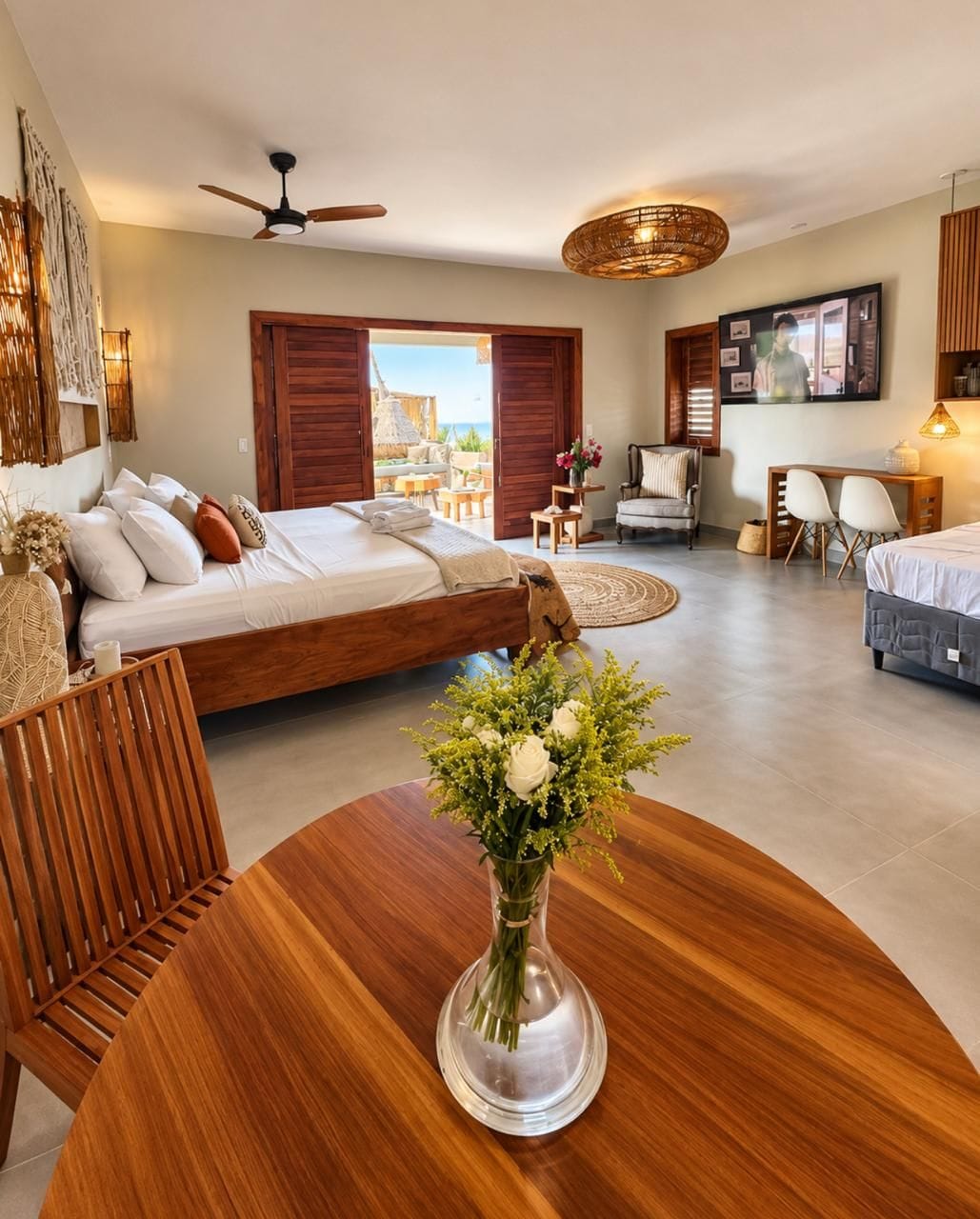 A modern bedroom with a bed, a desk, and a dining area.