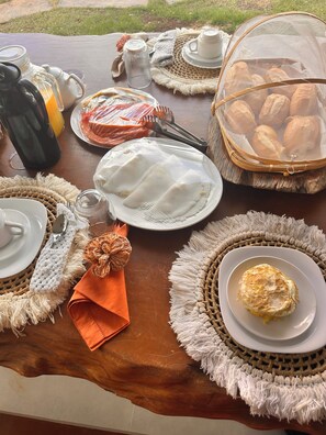 A table set with various dishes, including a plate of bread, a bowl of soup, and a plate with a single egg.
