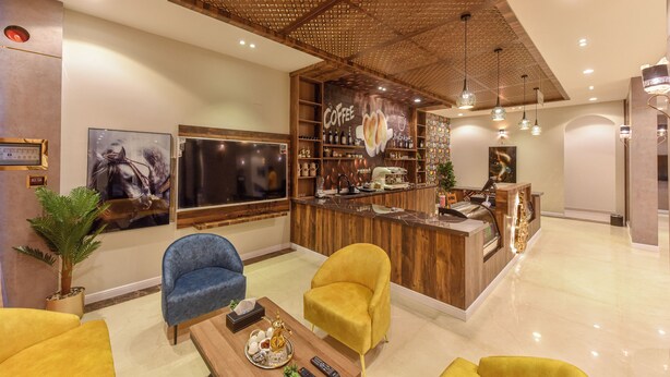 Un espace lounge moderne avec un comptoir d’accueil en bois, des sièges confortables et un grand téléviseur à écran plat.