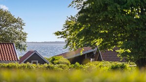 En kustutsikt med ett hus och en brygga för båtar.