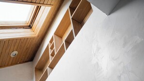 A modern interior with a sloped ceiling, wooden beams, and built-in shelves. - Short North, Free Parking, Italian Village (Columbus)