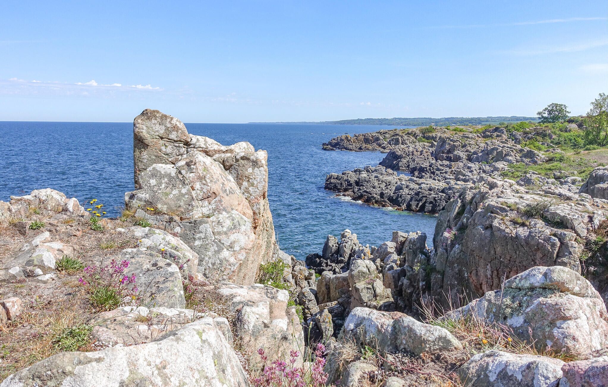 Eine Küstenlandschaft mit felsigem Gelände und Blick auf das Meer.