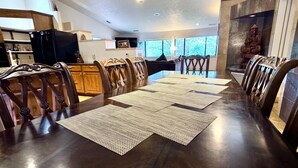 A dining area with a long table, wooden chairs, and a Buddha statue. - Serene Escape in West Sedona w/ Gorgeous Views (Sedona)