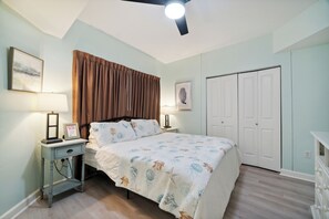 A bedroom with a bed, bedside tables, a ceiling fan, and a wardrobe. - Pineapple Paradise - Gulf Front 1BD + Bunk, 2BA, Sleeps 6 in Shores of Panama (Panama City Beach)