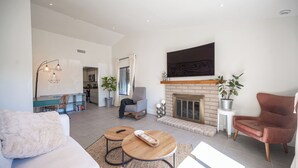 A modern living room with a fireplace, a sofa, a coffee table, and a dining area with a table and chairs. - Charming 3-bedroom house with WiFi and AC in wonderful Las Vegas (Las Vegas)
