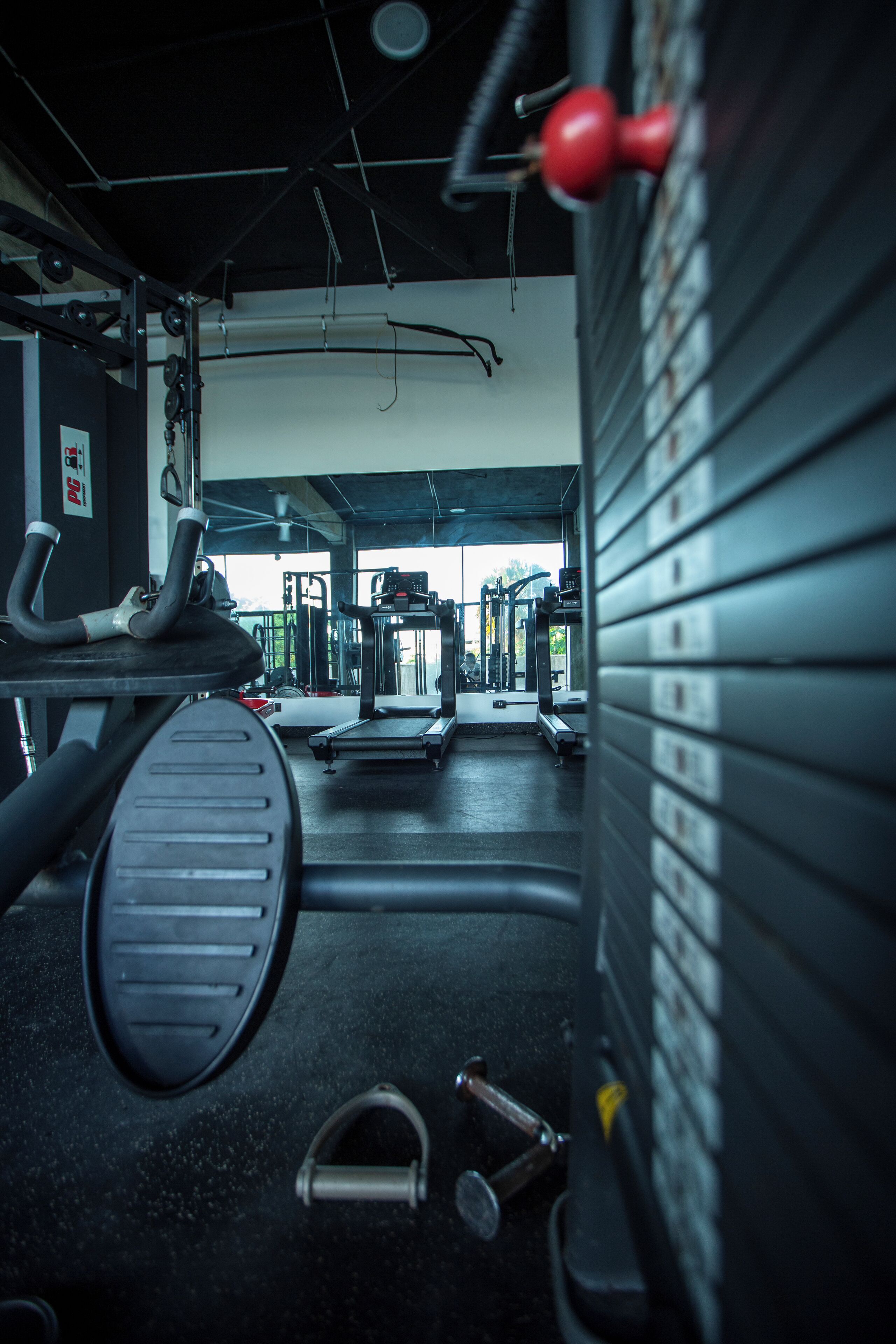Une salle de sport équipée de matériel d’exercice, d’un tapis de course et de supports pour les poids.