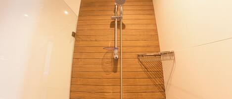 A shower with a wooden panel wall, a handheld showerhead, and a wall-mounted towel rack.