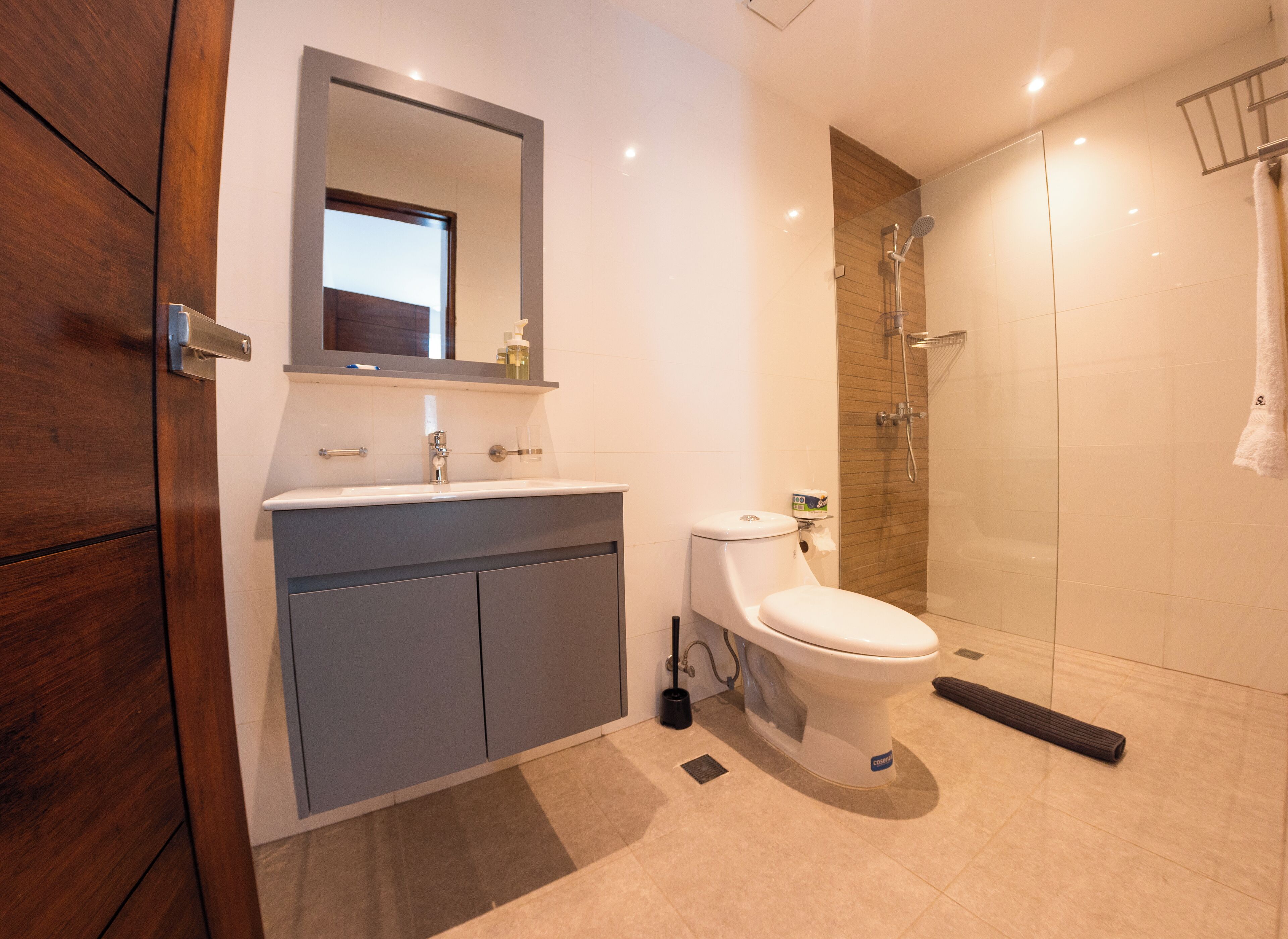 A modern bathroom with a toilet, sink, and shower.