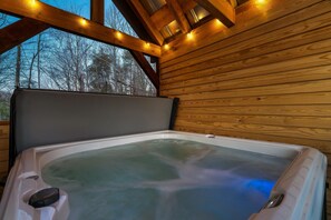 A hot tub with a wooden ceiling and a view of trees outside. - Amazing Location - Secluded/Private - Cozy 2-bedroom Log Cabin - Hot Tub (Sevierville)