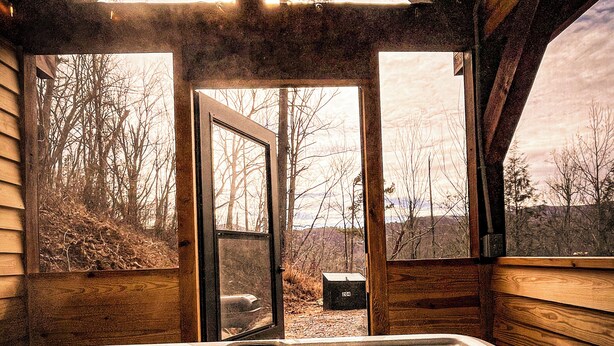 Un bain à remous avec vue sur une forêt, grâce à une grande fenêtre.