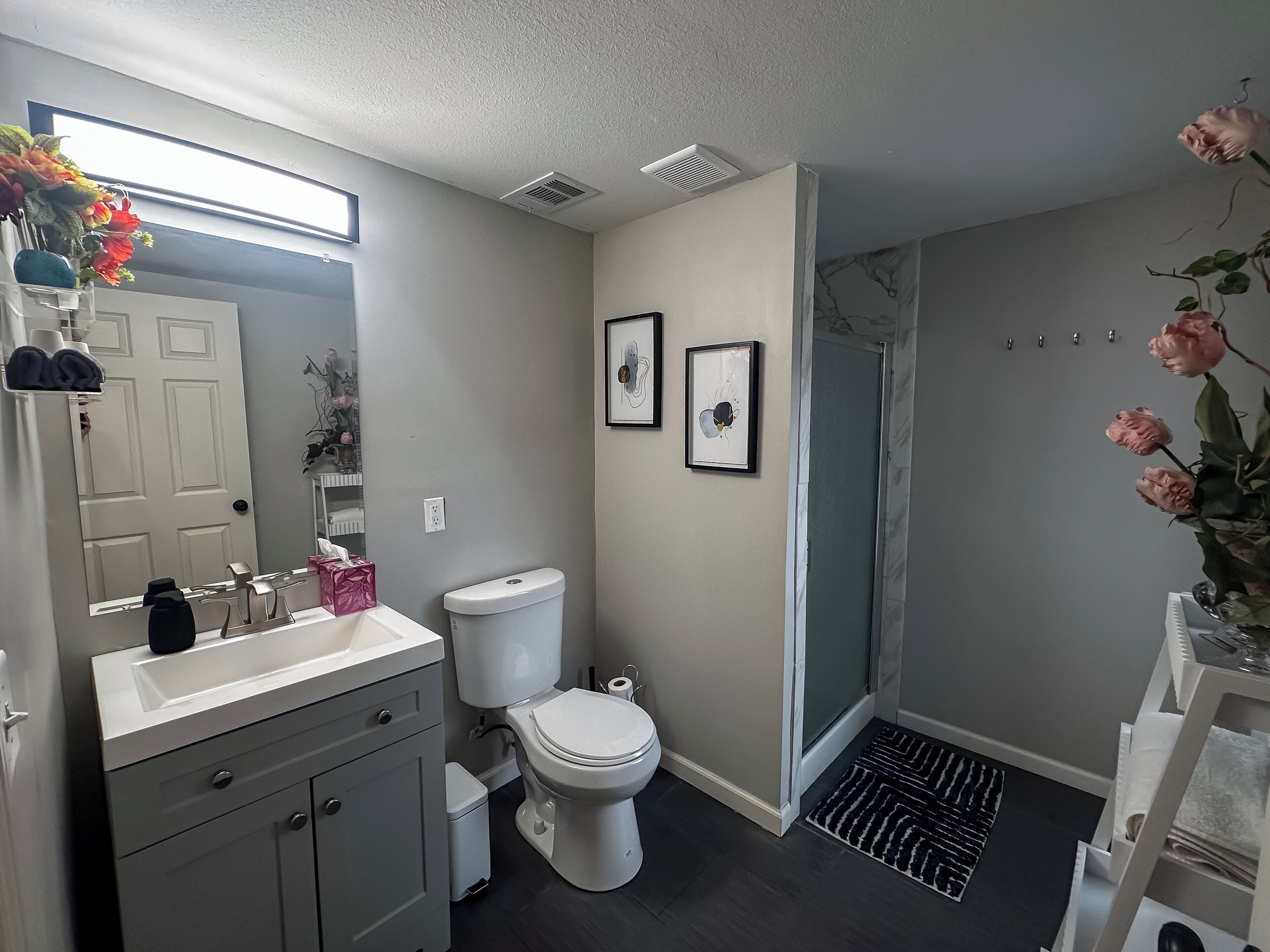 Un baño moderno con inodoro, lavabo y ducha.