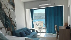 A hotel room with a bed, a sofa, a desk, and a view of the sea. - Villa Sedef (Neum)