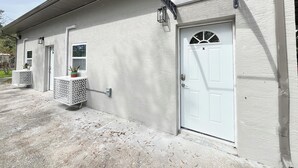 A building with a white exterior, a door with a number, and a small window.