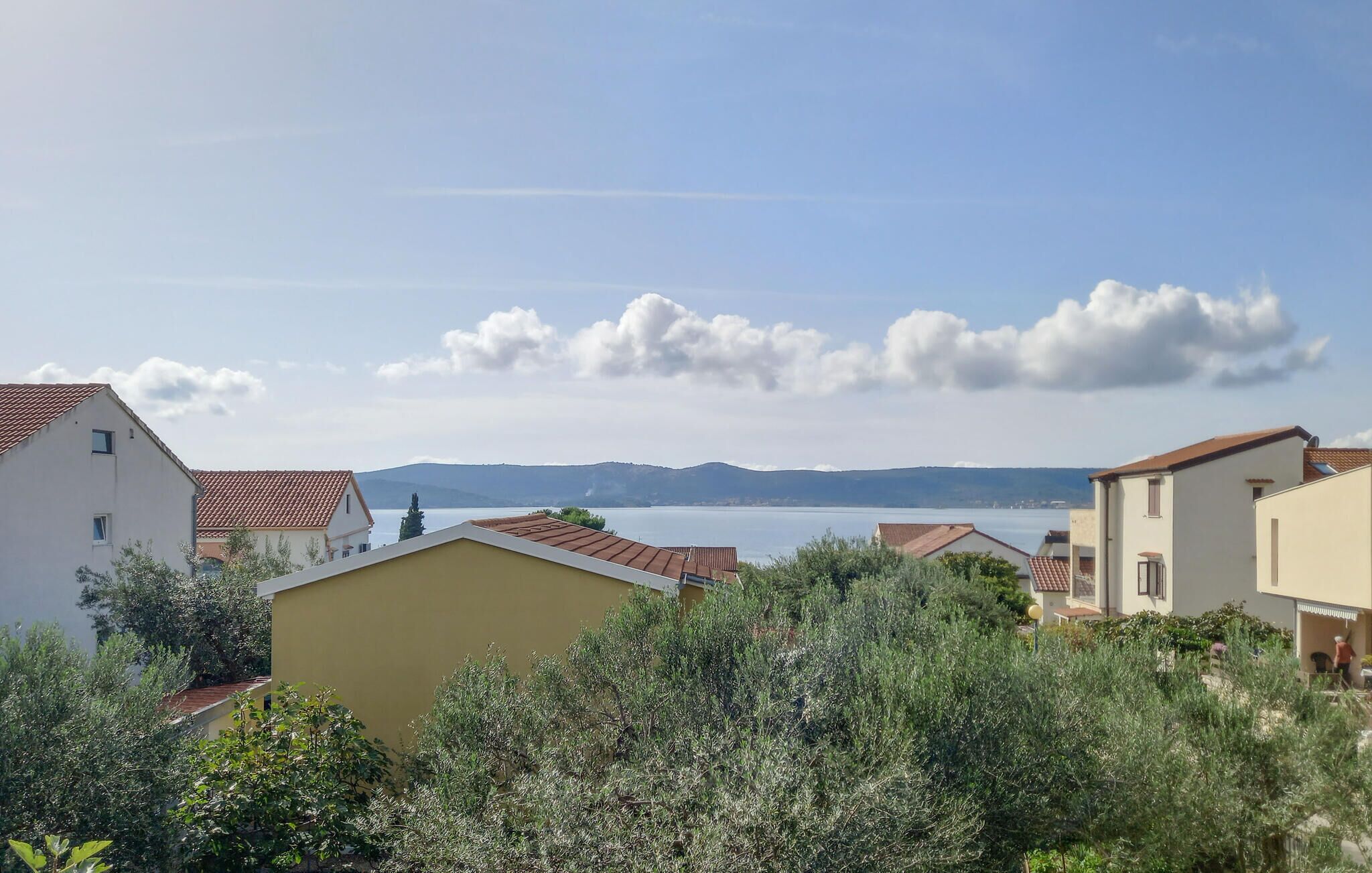 A residential area with houses, a clear sky, and a distant view of mountains.