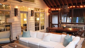 A cozy living area with a white sectional sofa, wicker furniture, and string lights. - Walking Distance to Square and Campus, Spacious 5-Bedroom House (Oxford)
